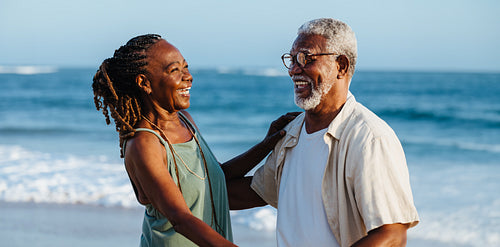 Happy older African American couple enjoying a seaside walk together