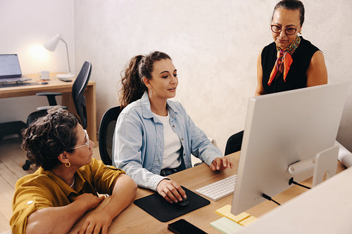 Team collaborating on project while discussing ideas in a modern office setting