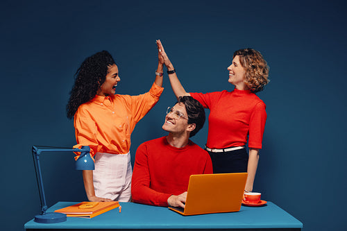 Group of colleagues celebrating success in the office