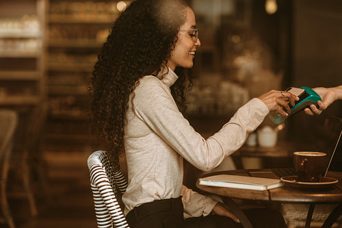 Customer paying using NFC technology in a cafe