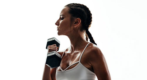Fitness model exercising with dumbbell