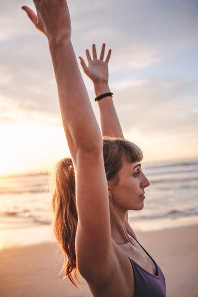 Female doing stretching exercise on the beach