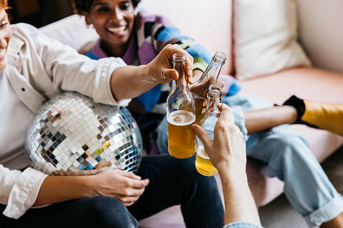 Friends toasting with beer bottles at a casual party