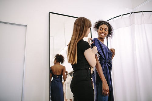 Fashion designer designing clothes in her fashion design studio along with a model