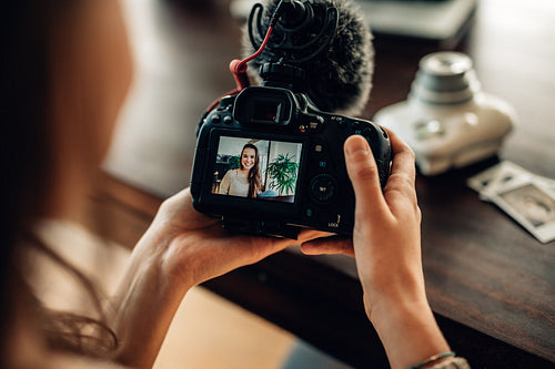 Blogger reviewing her recorded content on camera