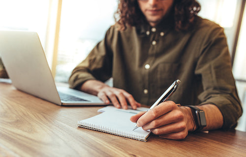 Businessman writing notes in a notepad