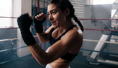 Female boxer training inside a boxing ring