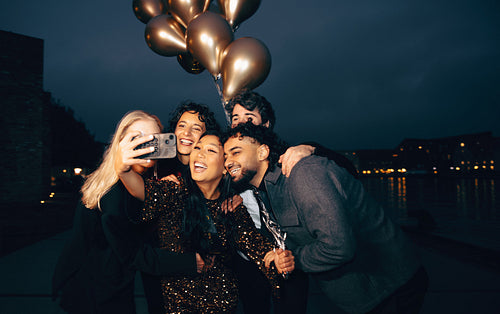 Outdoor New Year’s street party with friends and golden balloons