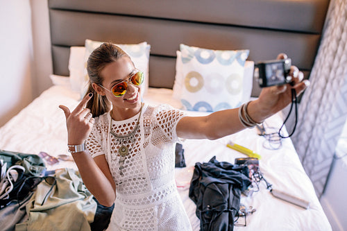 Young woman taking a selfie wearing colorful goggles.