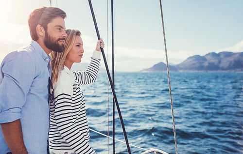 Young couple enjoying the view from a sailboat.