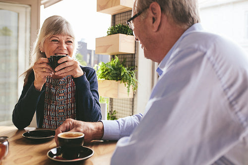 Smiling senior couple drinking coffee in cafe