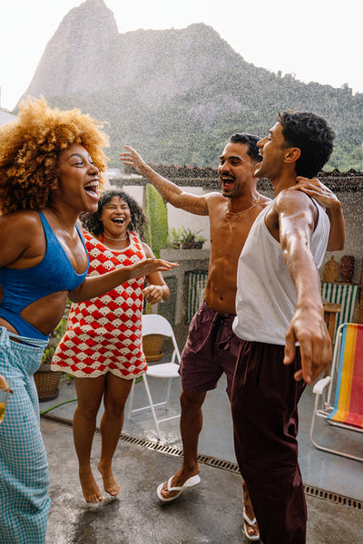 Friends laughing and cooling off with water on a hot summer day in Rio