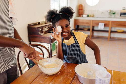 Young girl having fun making traditional cake with her brother in the kitchen