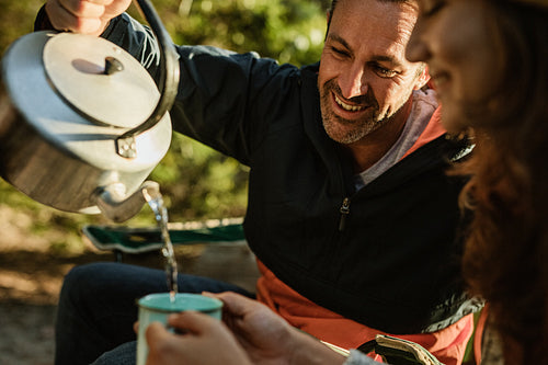 Couple having coffee at campsite