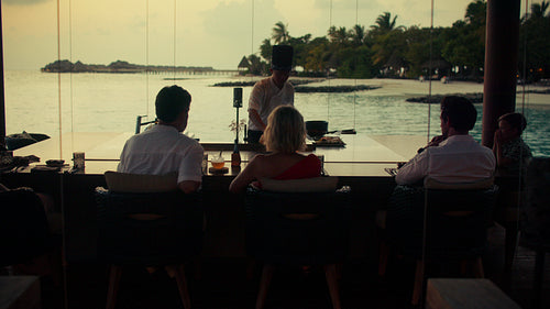 Chef performs an exciting teppanyaki fire show for delighted guests at a luxury resort restaurant