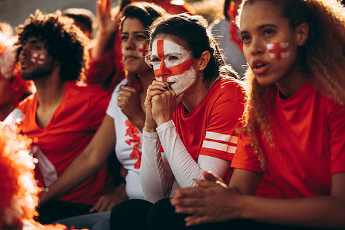 Anxious English soccer fans watching the game at stadium