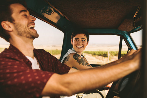 Young couple on a road trip driving in car