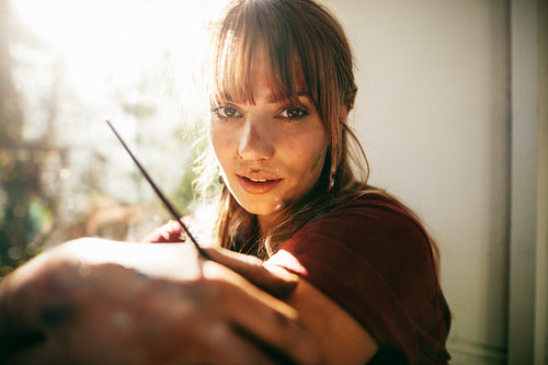 Beautiful female painter looking at camera