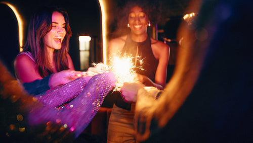 Women enjoying a sparkler during a fun night out celebration