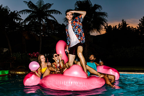 Group of men and women partying in the pool
