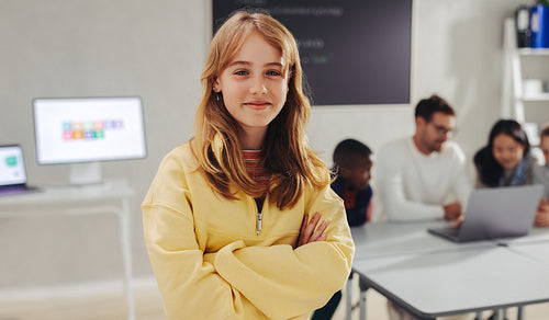 Ready to become the next coding expert, a young girl stands in a coding classroom