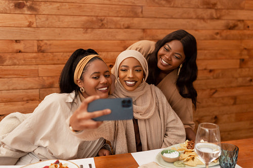 Multicultural friends taking a selfie together in a restaurant