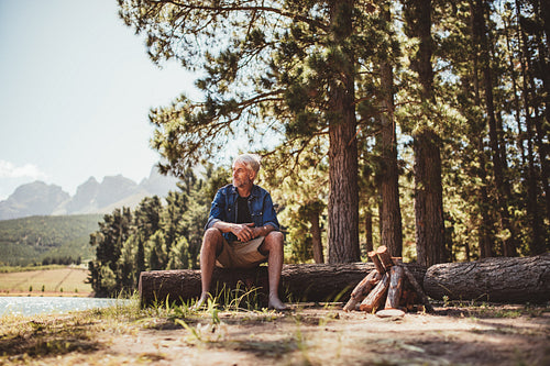 Mature man relaxing by a lake