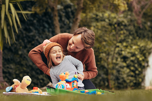 Father and daughter playing with toys in park