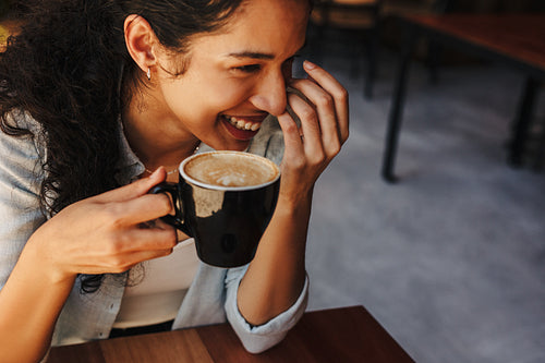 Woman holding cup of coffee and smiling