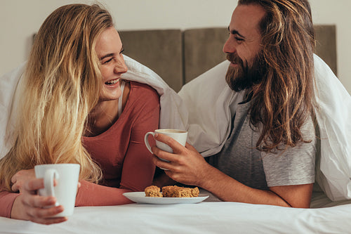Couple having breakfast on bed