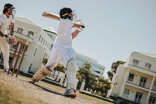 Male cricket batsman in action during a sunny outdoor match
