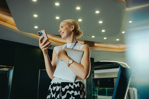 Confident female accountant in modern office with smartphone