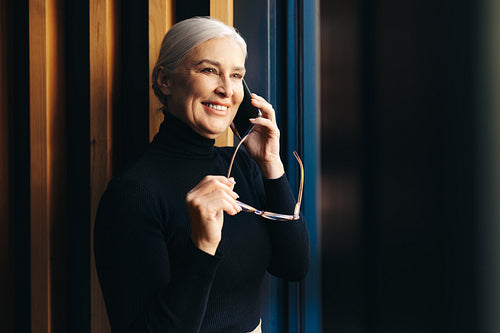 Business communications: Mature woman making a phone call in an office