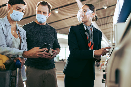 Airline attendant assisting tourist at airport