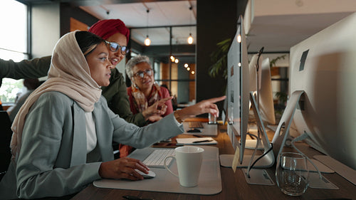 Multicultural business women discussing a digital marketing strategy on a computer