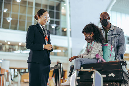 Airport staff at boarding gate assisting tourist family