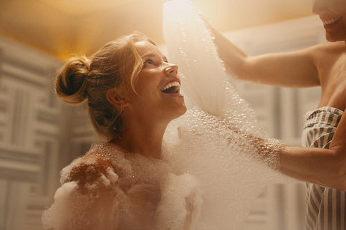 Joyful women in a luxurious hammam covered in bubbles