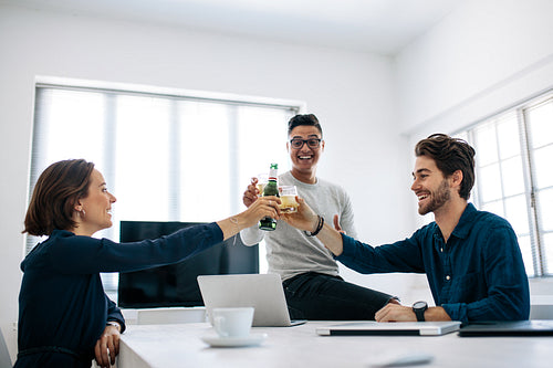 Office colleagues celebrating with drinks in office