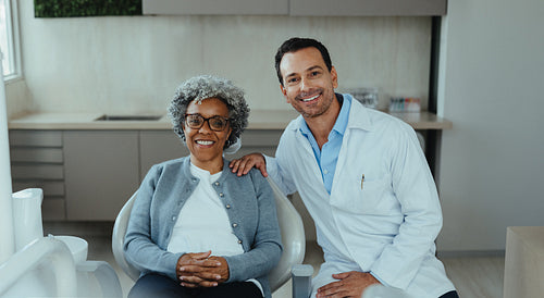 Dentist and senior patient stand together in a healthcare clinic during consultation