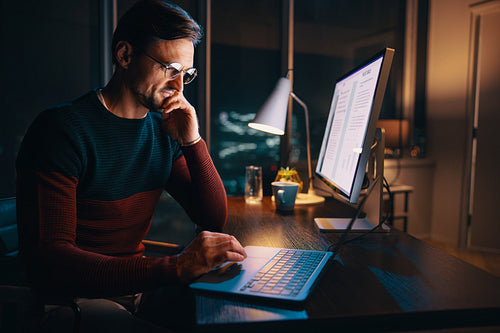 Business professional working late and having an online meeting on his laptop