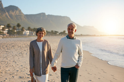 Happy senior couple taking a walk on the beach together