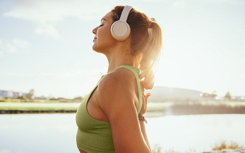 Woman in her 30s prepares to start her exercise routine on a sunny summer day