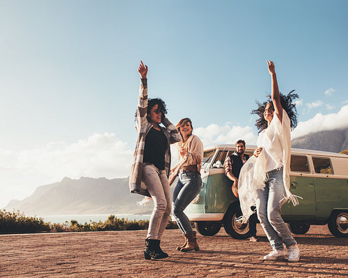 Friends dancing and having fun on road trip