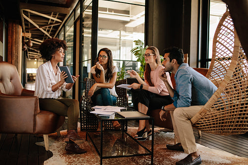 Young woman giving presentation to colleagues at office