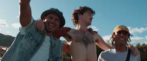 Happy male friends embracing at a music festival
