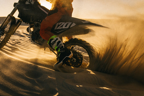 Motorbike rider churns up sand in the desert