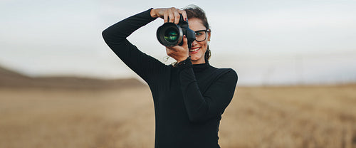 Professional female photographer shooting outdoors