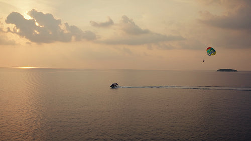 Parasailing over the tranquil ocean at sunset