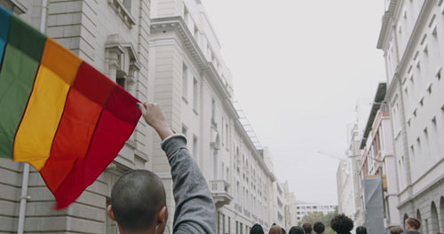Woman waving a rainbow flag at the gay parade