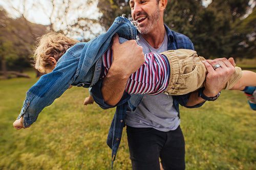 Father playing with son in park